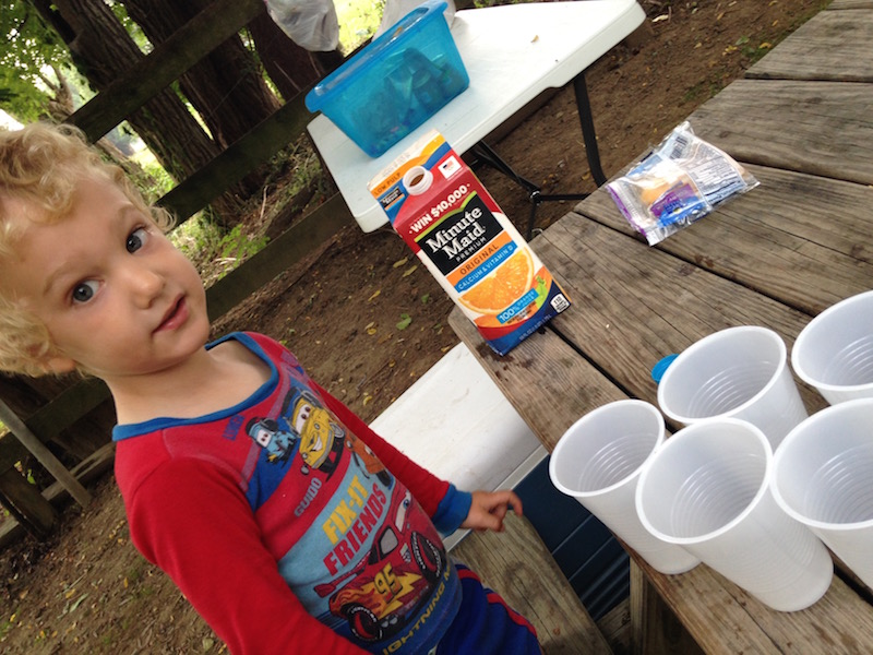 first camping trip with kids getting them involved pouring drink